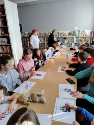 Dzieci uczą się rozpoznawać tropy leśnych zwierząt.