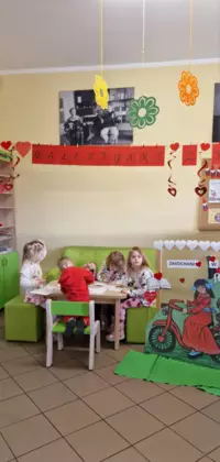 Grupa przedszkolaków w trakcie kolorowania walentynkowych obrazków.