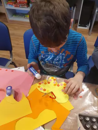 Chłopiec wykonuje pracę plastyczną.