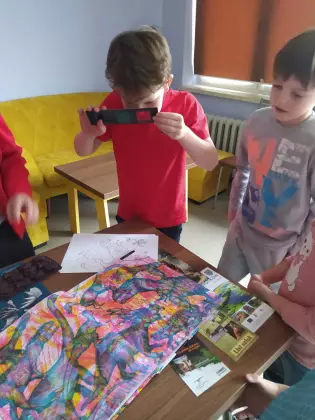 Dzieci oglądają książkę.