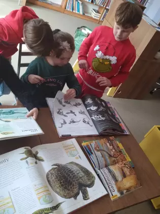 Dzieci oglądają książkę.