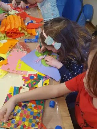 Dzieci tworzą motyle z papieru.