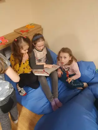 Dziewczynki czytają książkę.