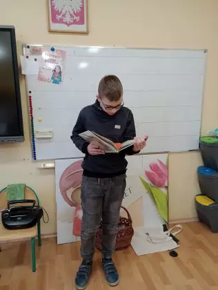 Chłopak czyta wiersz o wiośnie.