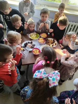 Dzieci jedzą poczęstunek.