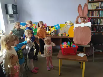 Dzieci oglądają dużego zajączka wyciętego z tektury.