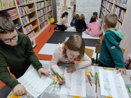 Chłopiec i dziewczynka rozwiązują zagadki związane z dinozaurami.