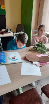 Chłopak i dziewczyna oglądają książeczkę.