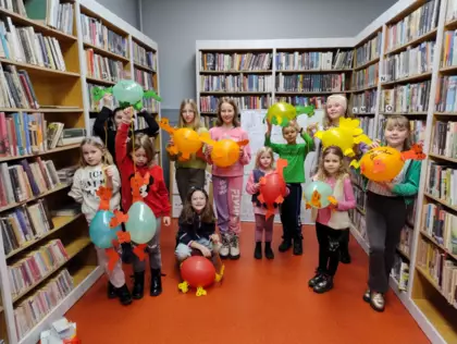 Zdjęcie grupowe ze stworzonymi z balonów dinozaurami.