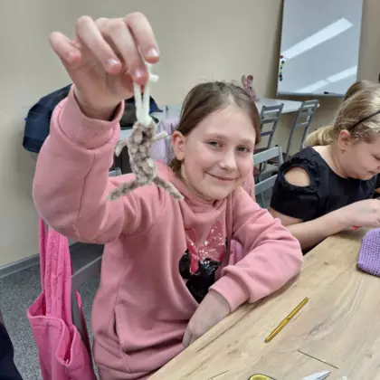 Uczestniczka zajęć pokazuje wyszydełkowaną skarpetkę.