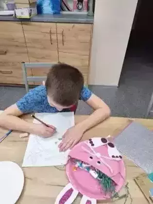 Chłopczyk pisze list do zajączka.