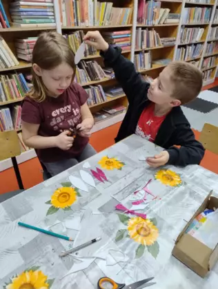 Chłopczyk i dziewczynka wycinają potrzebne elementy do stworzenia króliczka