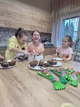 Dziewczyny lukrują upieczone babeczki.