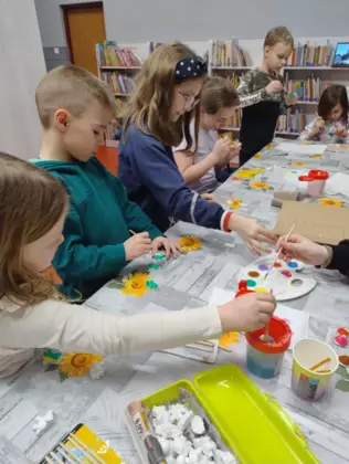 Dzieci malują farbkami magnesowe dinusie.