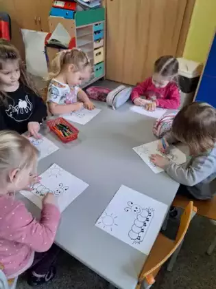 Maluszki kolorują obrazek stonogi.