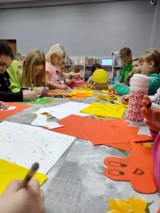 Grupa dzieci wykonują prace plastyczną.