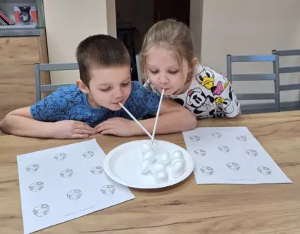 Dzieci bawią się w zbieranie jajeczek wielkanocnych.