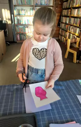 Dziewczynka wycina wazon potrzebny do kartki na dzień kobiet.