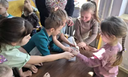 Przedszkolaki chowają Panią Zimę do pudełka.