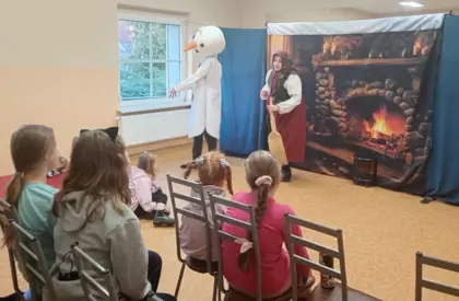 Teatrzyk Bałwanek ze śniegu dzieci siedzą na krzesełkach i oglądają przedstawienie.