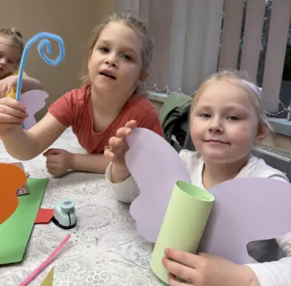 Dziewczynki z kolorowego papieru wycinają kolorowe motylki.