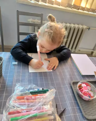 Dziewczynka koloruje wazon.