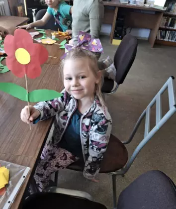 Dziewczynka ze swoim kwiatkiem na patyku.