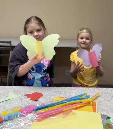 Dziewczyny z kolorowego papieru i rolki wykonują kolorowe motyle.