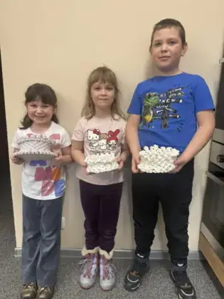 Troje dzieci z koszyczkiem w ręku.