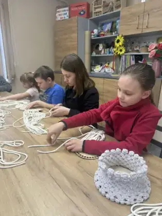 Uczestnicy splatają sznurki.