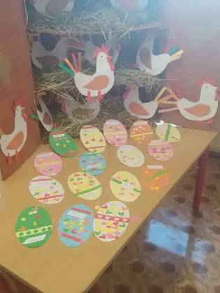 Na stole w bibliotece leżą prace plastyczne.