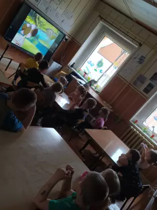 Dzieci oglądają bajkę na ekranie telewizora.
