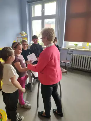 Dzieci otrzymują dyplomy za udział w konkursie.
