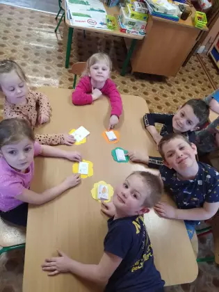 Przedszkolaki uśmiechają się do wspólnego zdjęcia.