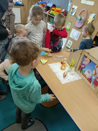 Dzieci oglądają teatrzyk kamishibai.