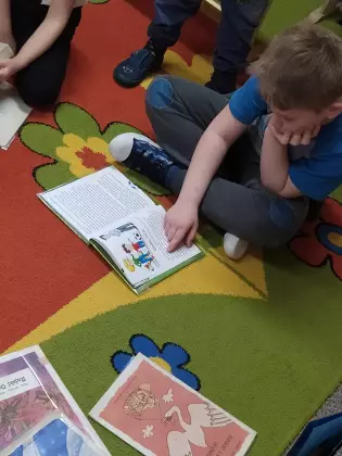 Chłopiec czyta książkę.