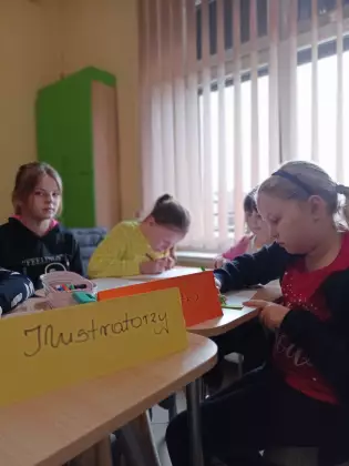 Dzieci malują obrazki do książki.