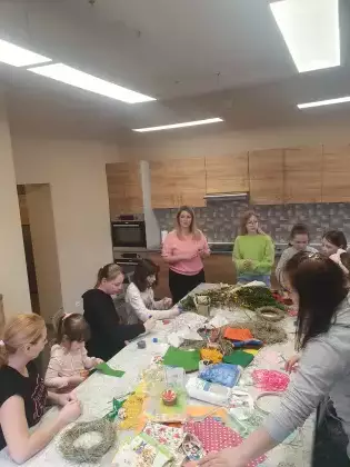 Uczestnicy warsztatów wykonują wianki wielkanocne ze słomy i siana.