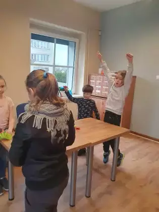 Dzieci bawią się skaczącymi żabkami.