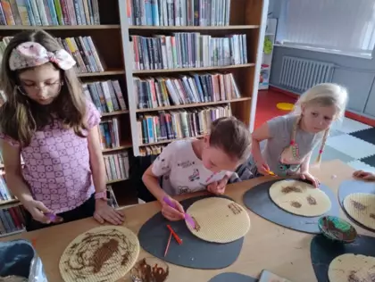 Uczestnicy zajęć smarują wafle roztopiona czekoladą tworząc arcydzieła.