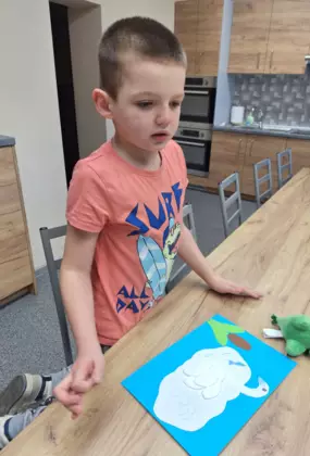 Chłopczyk wykonuje pracę plastyczną - łabędzia z płatków kosmetycznych