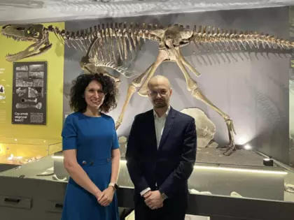 Wójt Gminy Pawonków Joanna Wons -Kleta i Dr Piotr Wojtulek w muzeum na tle szkieletu smoka.