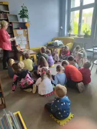 Przedszkolaki słuchają opowiadania o książce.
