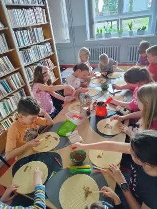 Uczestnicy zajęć smarują wafle roztopiona czekoladą tworząc arcydzieła.