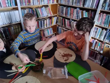 Uczestnicy zajęć smarują wafle roztopiona czekoladą tworząc arcydzieła.