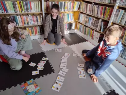 Dziewczynki i chłopak grają w karty.