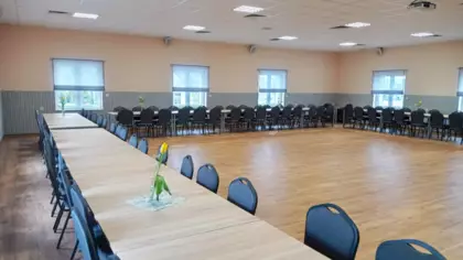 W sali stoją stoły oraz krzesełka.