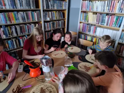 Uczestnicy zajęć smarują wafle roztopiona czekoladą tworząc arcydzieła.