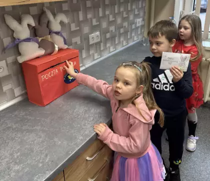 Uczestniczki zajęć wrzucają list do zajączka do skrzynki pocztowej.