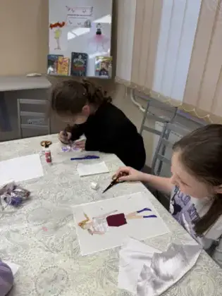 Dwie dziewczyny kolorują obrazek.